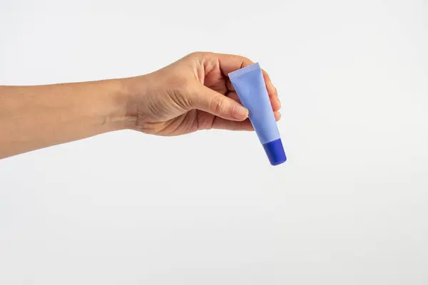 Beyaz arkaplanda krem, güneş kremi veya serum için mor paket.