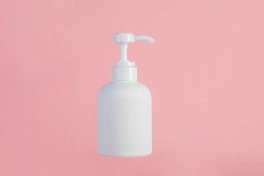 Orta boy beyaz şişe, pembe arka planı olan bir krema şişesi..