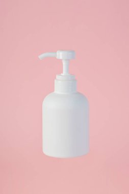 Orta boy beyaz şişe, pembe arka planı olan bir krema şişesi..