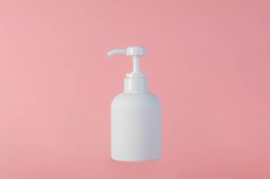 Orta boy beyaz şişe, pembe arka planı olan bir krema şişesi..