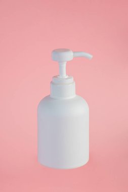 Orta boy beyaz şişe, pembe arka planı olan bir krema şişesi..