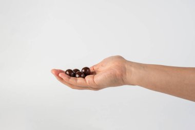 Beyaz arka planda elinde çikolata topu