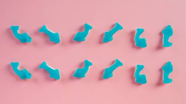 Denizanası şekerlemeleri. Jelibon köpek balığı, pembe arka planda şeker kaplı mavi yunus jölesi..