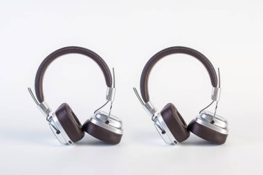İki tonluk gümüş ve kahverengi kablosuz kulaklık, kulaklıklar beyaz arkaplanda izole edilmiş. Kahverengi kablosuz kulaklık..