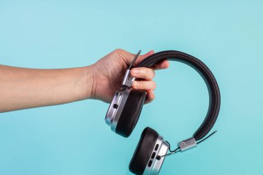 Two-tone silver and brown wireless headphones, Headphones isolate on blue background. Wireless headphones in brown.