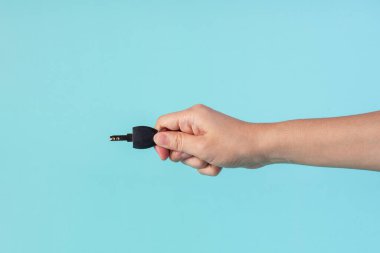 Black locker key in hand on blue background