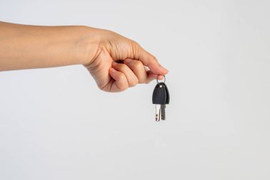 Black locker key in hand on white background