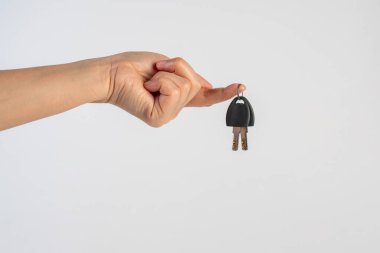 Black locker key in hand on white background
