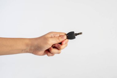 Black locker key in hand on white background