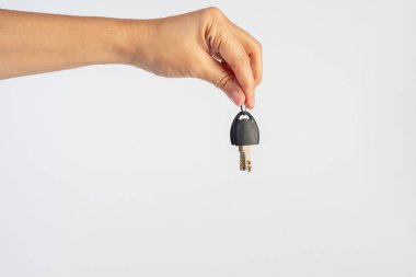 Black locker key in hand on white background