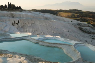 Yoğun turkuaz mavi su Pamukkale geçitlerinde sabahın erken saatlerinde, Denizli, Türkiye 2022