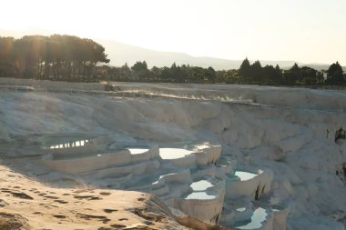 Pamukkale geçitlerindeki ilk güneş ışığı yansıyan sudan yükselen buhar, Denizli, Türkiye 2022