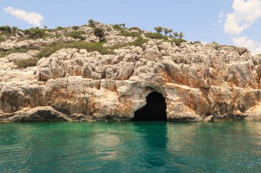 Gökkaya Körfezi yakınlarındaki Asirli Adası 'ndaki büyüleyici Korsan Mağarası veya Mavi Mağara, Türkiye 2022