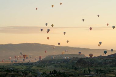Kızıl Vadi 'nin, gün doğumunda Gül Vadisi' nin üzerinde Goreme, Cavusin, Kapadokya, Türkiye 2022 'ye yakın birçok renkli sıcak hava balonu var.