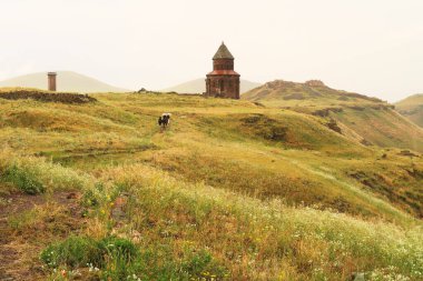 Yağmurlu bir günde şemsiyeler, Kale ve Minuchihr Camii 'nin Minaresi ile birlikte Abughamir, Abughamrens, Abughamrens ve Abughamrens Kilisesi' ne yürüyen insanlar arka planda, antik Ermeni kenti Ani, Kars, Türkiye 'de görülebilir.