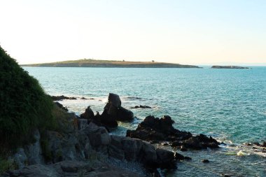 Sosopol 'un eski Sozopol kasabasındaki bir plajdan St. Ivan Adası' na, ön planda siyah kayalar, Bulgaristan 2022