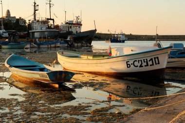 4 Temmuz 2022 'de Bulgaristan' ın Sosopol kentinin Sozopol kentinin yanındaki limanda, limanın altın saatinde suya yansıyan küçük balıkçı tekneleri