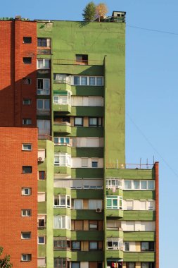 Renkli, turuncu ve yeşil sosyalist, gaddar beton panel, çok katlı, yüksek katlı, apartman bloğu, Prishtina, Priştine, Kosova 2022 şehir merkezinde bina