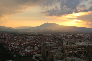 Günbatımında Prizren Kalesi 'nden manzara, harabeler, ön planda taş yapı ve eski kentin üzerinde renkli bir gökyüzü, arka planda şehir, Prizren, Kosova 2022