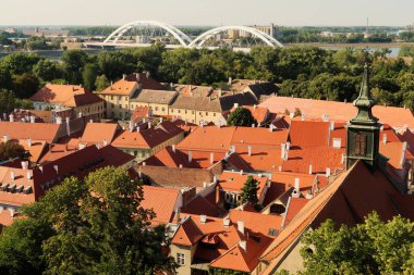 Petrovaradin Kalesi 'nden aşağı Patrovaradin Kalesi' ndeki binaların çatılarına, Saint George Kilisesi 'nin çan kulesine, sağdaki Juraj' a ve arkadaki Tuna Nehri üzerindeki Zezelj Köprüsü 'ne, Novi Sad, Se