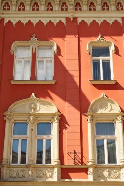 Sırbistan 'ın Subotica kentindeki Voynik Sarayı binasının kırmızı cephesinde pencereler 2022