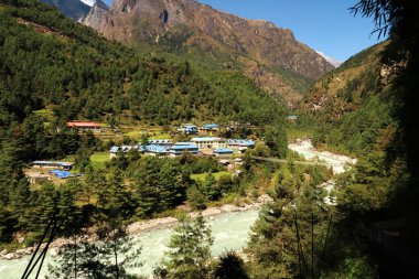 View onto the village of Phakding, right next to the Phakding suspension bridge over the Dudh Khosi River, Mount Everest Basecamp Trek, EBC, Nepal 2022 clipart