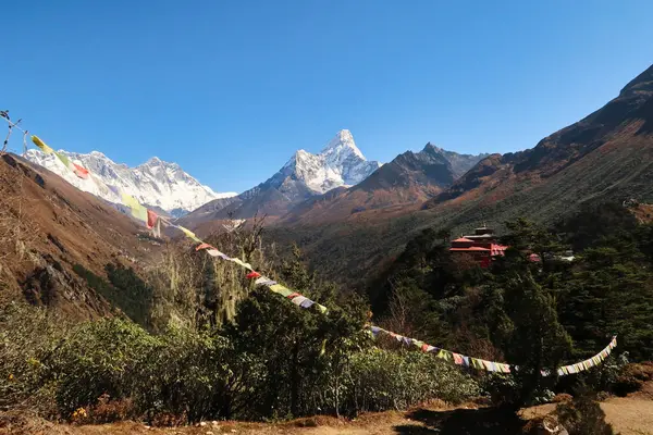 Önünde dua bayrağı olan Tengboche köyünün manastırına bakın. Arka planda Everest Dağı, Lhotse ve Ama Dablam tepeleri, Everest Ana Kamp Yolu, EBC, Nepal 2022