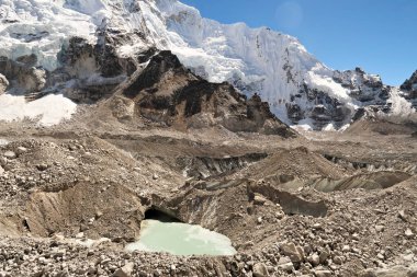 Khumbu Buzulu 'nda, taşlarla, kayalarla, çakıllarla, yeşil erimiş suyla kaplı olan su küçük havuzlarda, deliklerde, Everest Ana Kamp Gezisinde, EBC' de, Nepal 2022 'de toplanıyor.