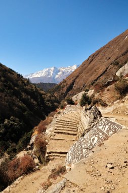 Tibetli Budist Mani, arka planda Kongde Ri tepesinin önündeki patika, merdivenler, Tengboche, Tangboche köyü, Everest Ana Kamp Yolu, EBC, Nepal 2022