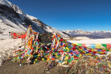 Thorong, Thorung, Thorang La Pass 'ın en yüksek noktasındaki işaret yüzlerce renkli dua bayrağı, Annapurna Pisti, Nepal 2022