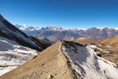 Thorong La 'dan Thorung La' ya, Thorang La 'dan Muktinath' a giderken, bir dağ sırası boyunca uzanan yolda bir kişi yürür, Annapurna Pisti, Nepal 2022