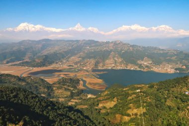 Phewa Gölü 'nün önünde Machapuchare Dağı' nın ortasında, Pokhara, Nepal 2022 yakınlarındaki Dünya Barış Pagoda 'sına uzanan dağ sırasına bakın.