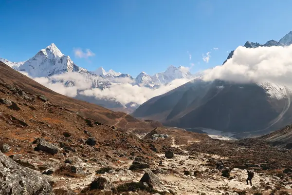 stock image Walking up towards the Everest Memorial Chukpi Lhara, the Dughla, Thukla village in the foreground, Mount Amphu Gyabjen, Ama Dablam, Kangtega and Thamserku in the background, Mount Everest Base Camp Trek, EBC, Nepal 2022