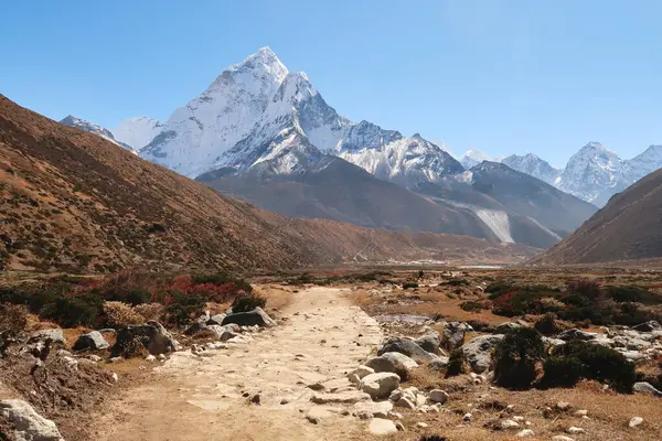 stock image Walking through Pheriche valley, Pheriche village in the distance in front of Mount Amphu Gyabjen, Ama Dablam, Kangtega and Thamserku, Mount Everest Base Camp Trek, EBC, Nepal 2022