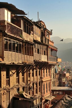 Renkli, geleneksel bir mesken, apartman, ev, konut, şehir merkezindeki konut, altın saatinde eski Bhaktapur kasabası, yanında bir kuş uçuyor, Bhaktapur, Nepal 2022