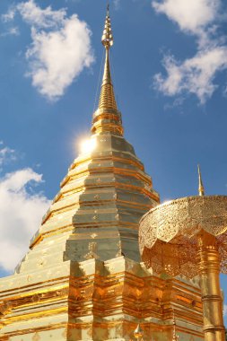 Altın merkezi stupa, mavi gökyüzünün önündeki pagoda Wat Phra 'daki Doi Suthep Tapınağı' nın altın şemsiyesinin yanında güneş ışığı yüzeyinden yansıyor, Chiang Mai, Tayland 2023