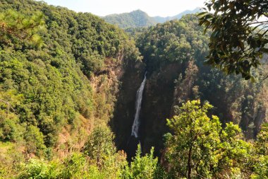 Spectacular view onto the Nam Tok Mae Surin Waterfall, surrounded by a lush, dense forest, jungle, vegetation, close to Khun Yuam, Thailand 2023 clipart