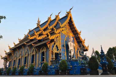 Mavi Tapınak 'ın, Wat Rong Suea 10, Chiang Rai, Tayland 2023' teki özenle hazırlanmış ön cephesine, çatısına ve beyaz Buda heykeline bakın.