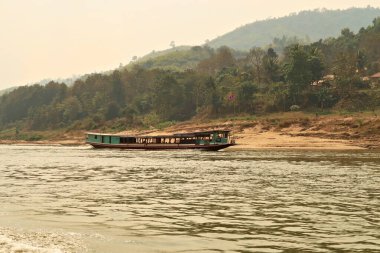 Tayland 'dan Laos' a giden yavaş teknede Mekong Nehri 'nde bir başka yavaş tekne daha geçiyor, Laos 2023.