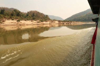 Tayland 'dan Laos' a giden yavaş tekneden Mekong Nehri 'ne manzara suyun pürüzsüz yüzeyi Laos 2023' ü yansıtıyor.