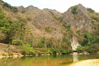 Kıyıdan, nehrin sahilinden Kong Lor Mağarası 'nın girişine, Thakhek Motosiklet Döngüsü' nde turistik bir yere, Laos 2023.