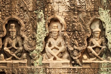 Prasat Preah Khan Tapınağı 'nın kumtaşına oyulmuş levrek kabartması, üst üste üç rahip, Angkor Wat, Siem Reap, Kamboçya 2023 dua ediyor.