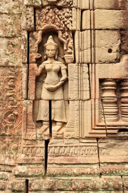 Ta Som Tapınağı 'nın kumtaşı duvarına bir apsara oyulmuştur. Tuğlaları arasındaki boşluklar, çatlaklar, Angkor Wat, Siem Reap, Kamboçya 2023.
