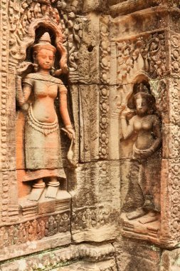 Ta Som Tapınağı, Angkor Wat, Siem Reap, Kamboçya 2023 'ün kumtaşı duvarına oyulmuş iki apsaras ve diğer süsler.