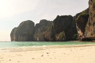 Maya Körfezi 'nde, beyaz plajın manzarası, turkuaz deniz ve yüksek Karst kayaları, Ko Phi Lee, Tayland 2023