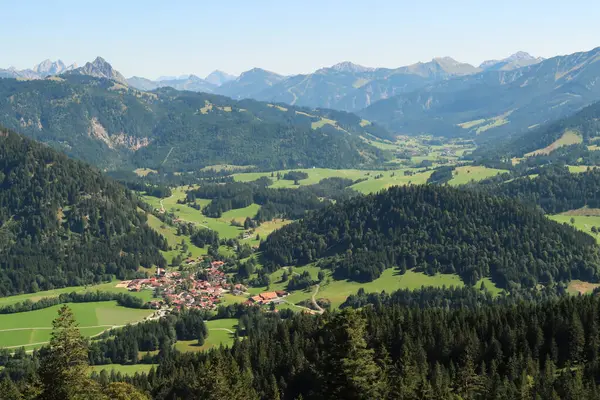 Ormanlar, Tannheimer Tal vadisi ve arka plandaki Alp dağları, Allgaeu, Allgovia, Baravia, Almanya 2023 arasında yer alan küçük köye bakın.
