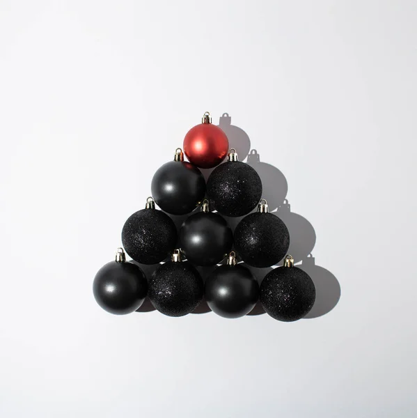 Κόκκινα Και Μαύρα Χριστουγεννιάτικα Στολίδια Στοιβαγμένα Σχήμα Χριστουγεννιάτικου Δέντρου Λευκό — Φωτογραφία Αρχείου