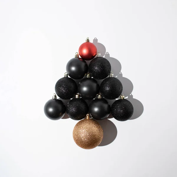 白い背景にクリスマスツリーの形に積み上げ赤と黒のクリスマスの泡 最小挨拶の概念 — ストック写真