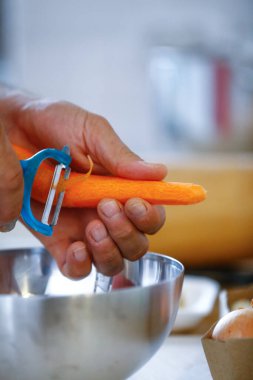 Erkek eli yemek taşır. Mutfakta sebze pişirir.