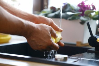 Erkek eli yemek taşır. Mutfakta sebze pişirir.